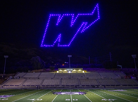 Drones make a lit "W" above the football field.