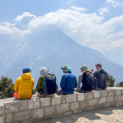 Outdoor Program employees sit overlooking Himalayan Mountains